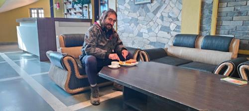 a man sitting at a table with a plate of food at Hotel August International in Pokhara