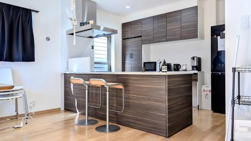 a kitchen with a counter with stools in it at UND STAY Premium Luxury Vacation 別府 鉄輪 in Beppu