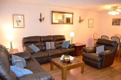 un soggiorno con divano e sedie in pelle marrone di 5 Vaqueria Lane a Hot Springs Village