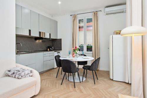 une cuisine et une salle à manger avec une table et un réfrigérateur dans l'établissement Le Castillon, à Beausoleil