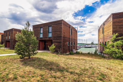 a wooden house next to a body of water at LAGOVIDA Hafenhaus j am Störmthaler See in Großpösna