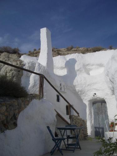 a white building with a table and chairs in front of it at Al Jatib in Baza