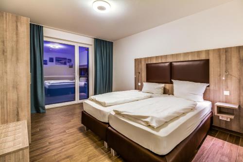 a bedroom with a large bed and a large window at LAGOVIDA Leuchtturm am Störmthaler See in Großpösna