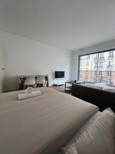 une chambre avec un grand lit et une grande fenêtre dans l'établissement View of Eiffel Tower Paris 16th arrondissement Trocadero with Terrasse, à Paris