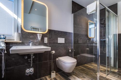 a bathroom with a toilet and a sink and a shower at LAGOVIDA Kapitänskajüte a am Störmthaler See in Großpösna