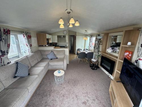 an rv living room with a couch and a table at Golden Palm Resort - Willerby Avonmore - Coastal Caravan Breaks in Chapel Saint Leonards