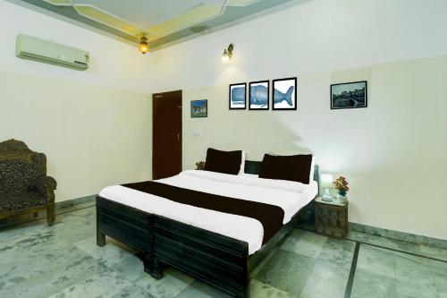 a bedroom with a large bed in a room at Super Hotel O Sikar Road Jaipur Formerly Garg Niwas in Jaipur