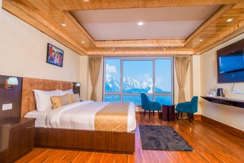 a bedroom with a bed and a large window at Divine The Celeste, Pelling in Pelling