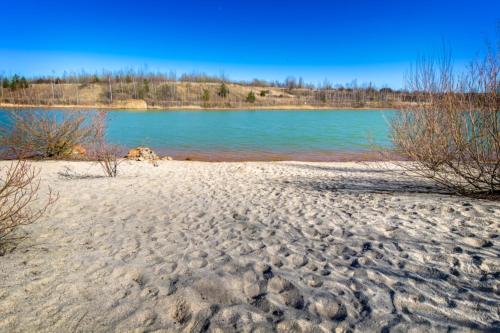 una spiaggia sabbiosa con una cassa d'acqua di LAGOVIDA Dünenhaus Comfort Familia b am Störmthaler See a Grosspösna