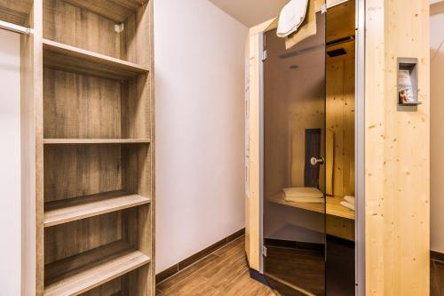 a walk in closet with wooden shelves and a door at LAGOVIDA Möwenblick c am Störmthaler See in Großpösna