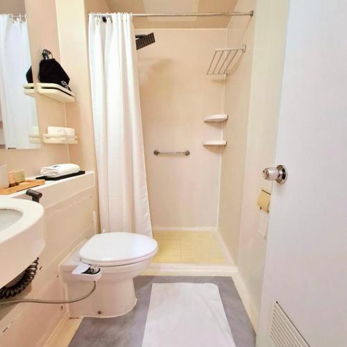 a small bathroom with a toilet and a shower at BREATHTAKING BAYVIEWS - 1-5 BR Luxury and Superior Condos with Panoramic Bay Views, Balcony, Gym, Pool & Netflix - Housekeeping Available - in Manila