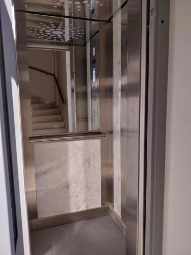 a glass elevator in a building with a staircase at Etherial Comfy House 2 in Kalamata