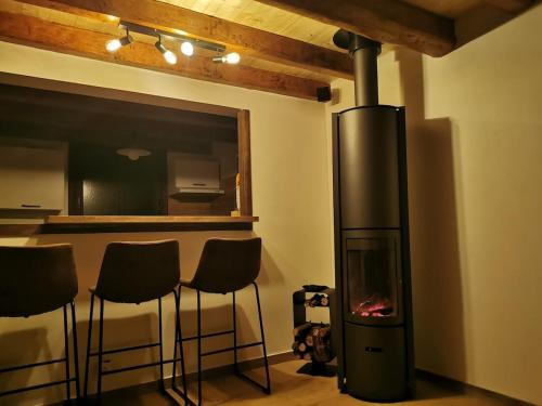 - une cheminée dans le salon avec deux tabourets dans l'établissement Maison de campagne idéale pour séjour en famille, à Porto-Vecchio