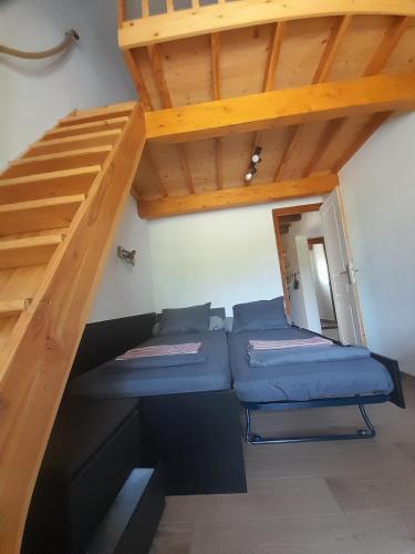 - une chambre avec 2 lits sous un escalier en bois dans l'établissement Maison de campagne idéale pour séjour en famille, à Porto-Vecchio
