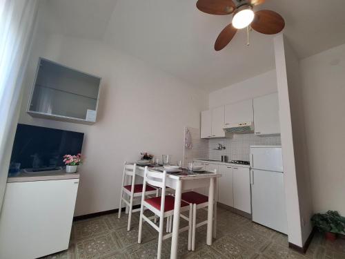 a kitchen with white cabinets and a table with chairs at Residence Zenith in Caorle
