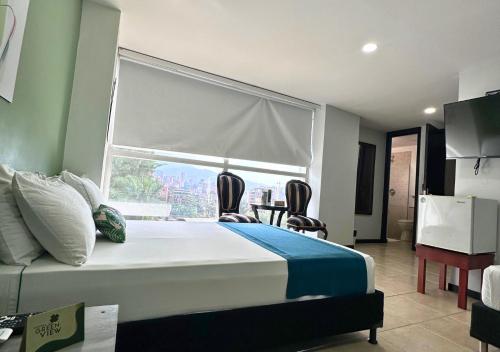 a bedroom with a bed and a large window at Greenview Medellin By St Hoteles in Medellín