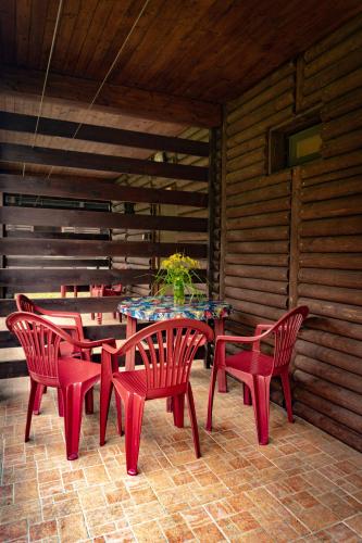a patio with red chairs and a table with a plant at Komáří Louka in Nová Olešná