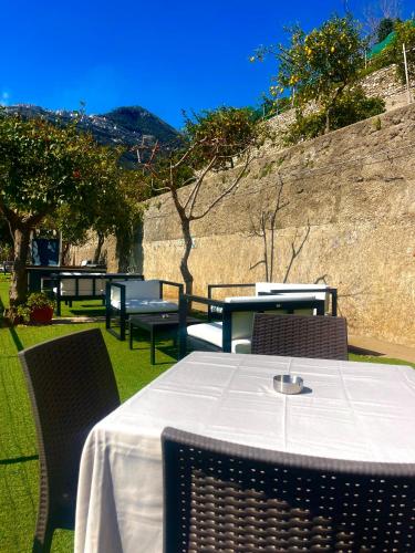a table with a white tablecloth and chairs on the grass at Eden Holiday in Minori