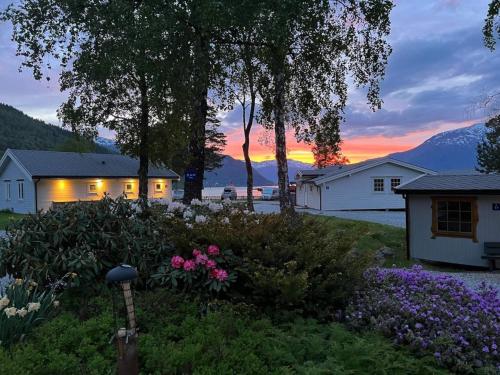 a house with a garden in front of a sunset at Family-friendly cottage in Kinsarvik in Kinsarvik
