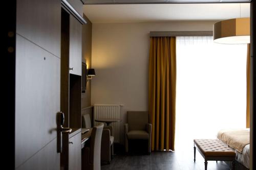 a hotel room with a bed and a table and chairs at Blanckthys Hotel Voeren in Voeren