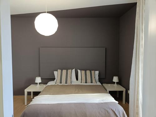 a bedroom with a large bed with two side tables at B&B Sbarco dei 1000 in Marsala
