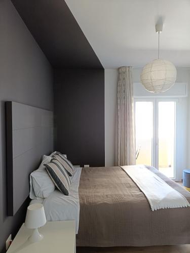 a bedroom with a large bed and a large window at B&B Sbarco dei 1000 in Marsala