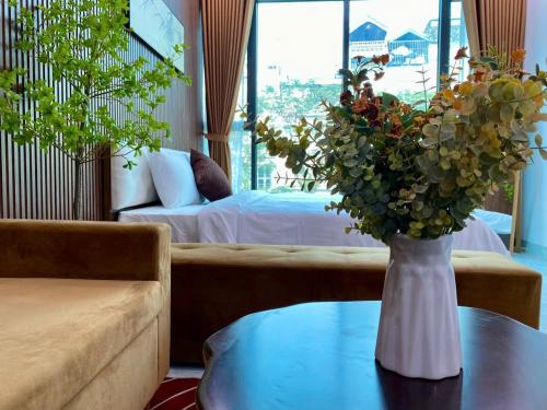 a living room with a vase of flowers on a table at The Grand Diamond C Tuong Mai in Hanoi