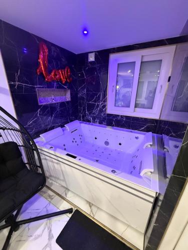 a bath tub in a room with a purple ceiling at Love room spa in Choisy-le-Roi