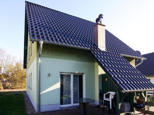 a green house with a roof with a bird on top at Doppelhaushälfte, Zingst in Zingst