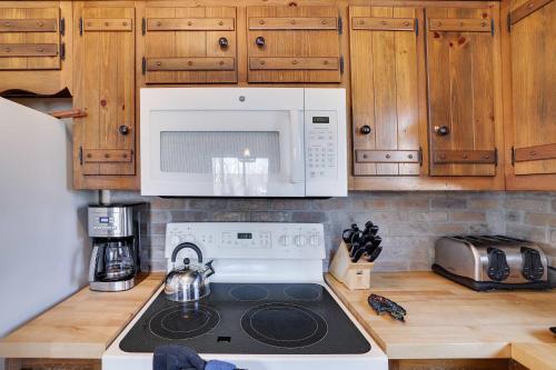 a kitchen with a microwave and a stove top oven at 4 Br Cozy Cabin Sleeps 8 Pool Table Arcade Beach in Gouldsboro