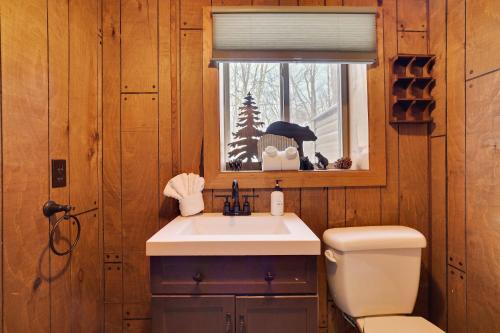 a bathroom with a sink and a toilet and a window at 4 Br Cozy Cabin Sleeps 8 Pool Table Arcade Beach in Gouldsboro