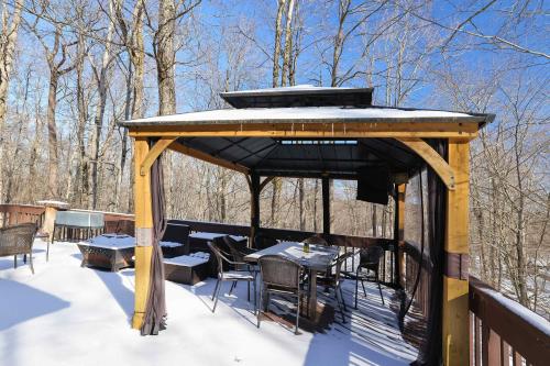 a gazebo with tables and chairs on a deck at 4 Br Cozy Cabin Sleeps 8 Pool Table Arcade Beach in Gouldsboro
