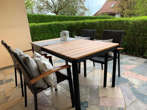 a wooden table and chairs on a patio at Ferienwohnung Rhönauszeit in Stockheim