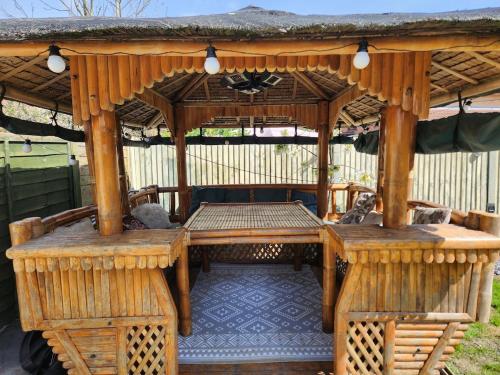 a wooden gazebo with a table and chairs at 4 Bed 3 Bath Dryer Sky TV & Netflix Free Parking Rear Garden Prime Location in Willen