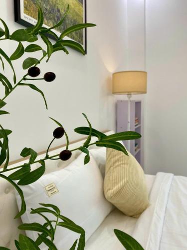a green plant sitting on a bed next to a lamp at The Grand Diamond C Tuong Mai in Hanoi