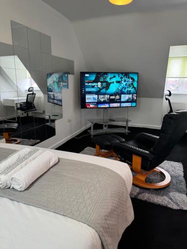 a bedroom with a bed and a flat screen tv at Home Away from Home in Milton Keynes