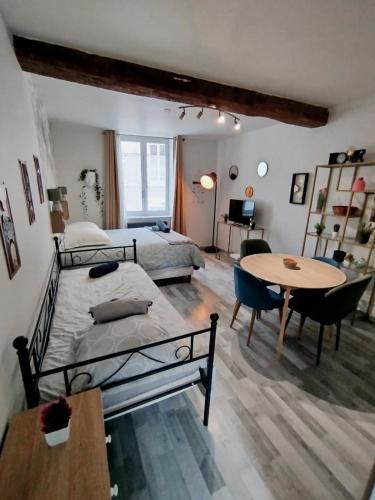 une chambre avec un lit, une table et un bureau dans l'établissement Sleep'in Orléans centre-studio confortable et cosy, à Orléans