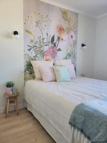 - une chambre avec un lit orné d'un mur fleuri dans l'établissement Villa Mado, à 2 pas de la plage, à Saint-Gilles-Croix-de-Vie