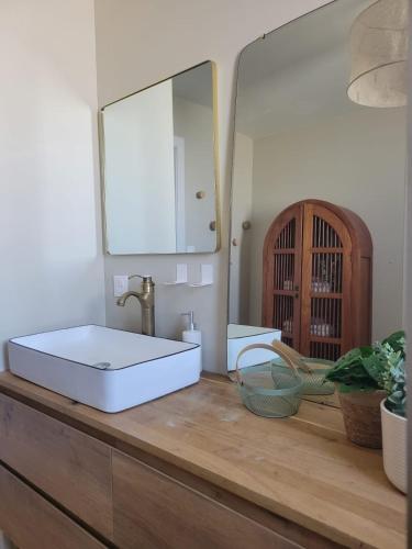 une salle de bain avec un lavabo et un miroir dans l'établissement Villa Mado, à 2 pas de la plage, à Saint-Gilles-Croix-de-Vie