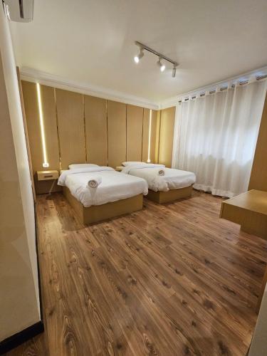 two beds in a room with wooden floors at Sheraton Ocean 103 - Without Pool access in Cairo