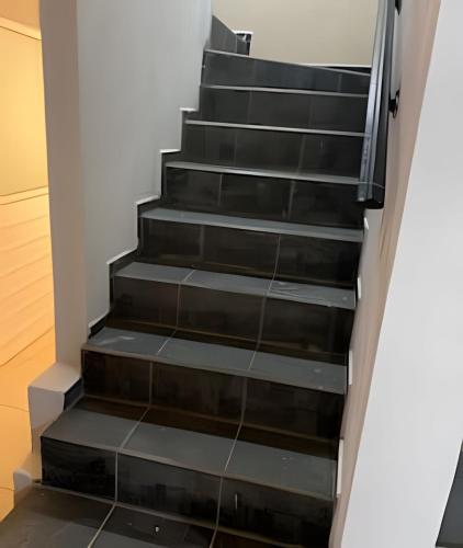 a staircase in a house with black steps at C12 · Casa 2 niveles, alberca y vista al manglar in Peñita de Jaltemba
