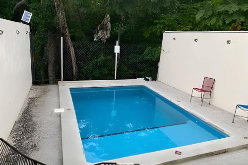 a swimming pool on a patio with two chairs at C12 · Casa 2 niveles, alberca y vista al manglar in Peñita de Jaltemba