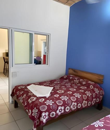 a bedroom with a red bed with a window at C4 Alberca privada a 5 min de la playa planta alta in Peñita de Jaltemba