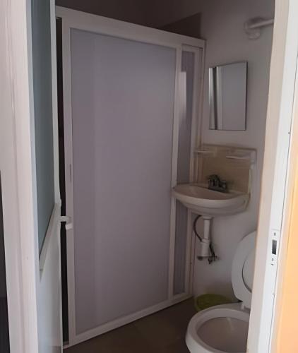 a bathroom with a toilet and a sink at C4 Alberca privada a 5 min de la playa planta alta in Peñita de Jaltemba