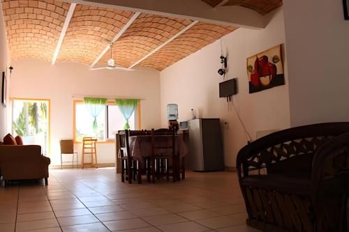 a living room with a table and a refrigerator at C2 Alberca privada a 5 min de la playa, en planta alta in La Peñita de Jaltemba