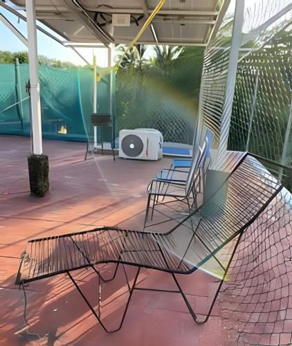 two chairs and a net on a tennis court at C4 Alberca privada a 5 min de la playa planta alta in Peñita de Jaltemba