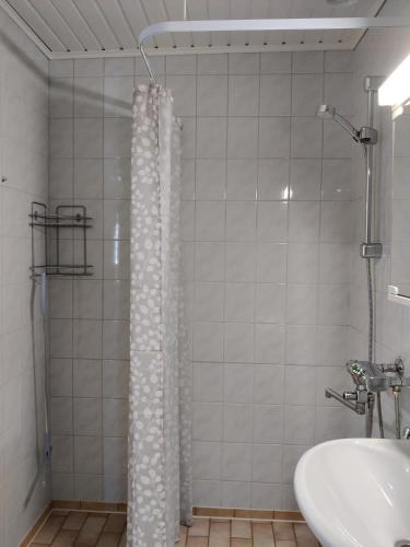 a bathroom with a shower curtain and a sink at Rivitalokaksio, Kinnula in Kinnula