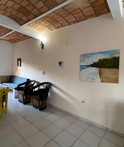 a living room with chairs and a painting on the wall at C4 Alberca privada a 5 min de la playa planta alta in Peñita de Jaltemba