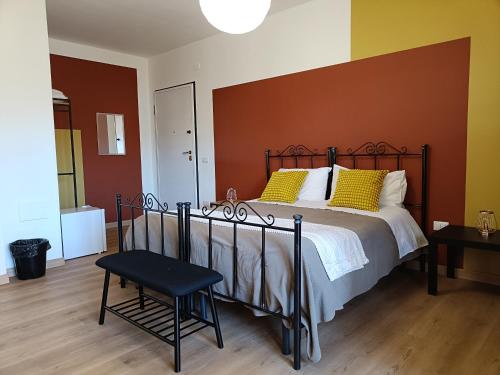 a bedroom with a bed with yellow pillows and a chair at B&B Sbarco dei 1000 in Marsala