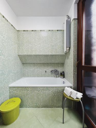 baño con bañera y taburete amarillo en Le Terrazze Ciampino, en Ciampino